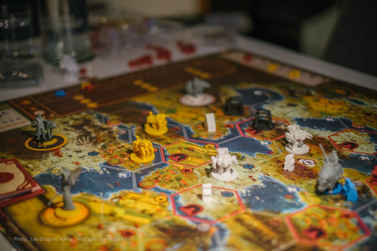 Boîte et figurines du jeu de plateau Scythe disposées sur une table de jeu